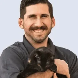 Dr Pietro Catini posing for a picture with a black kitten